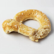 partially eaten protein pretzel with coarse salt on a white plate