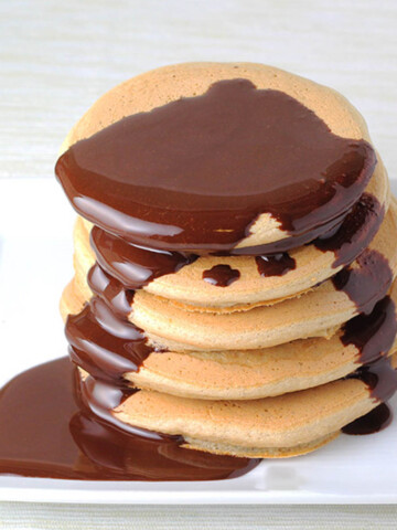 stack of protein pancakes with chocolate syrup dripping