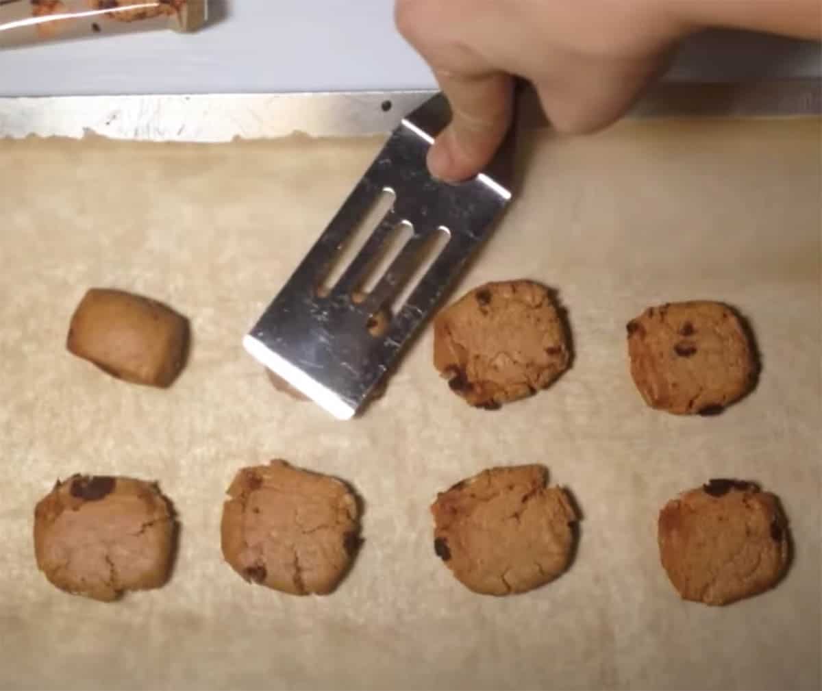 quest bar cookies being flattened with a mini spatula.