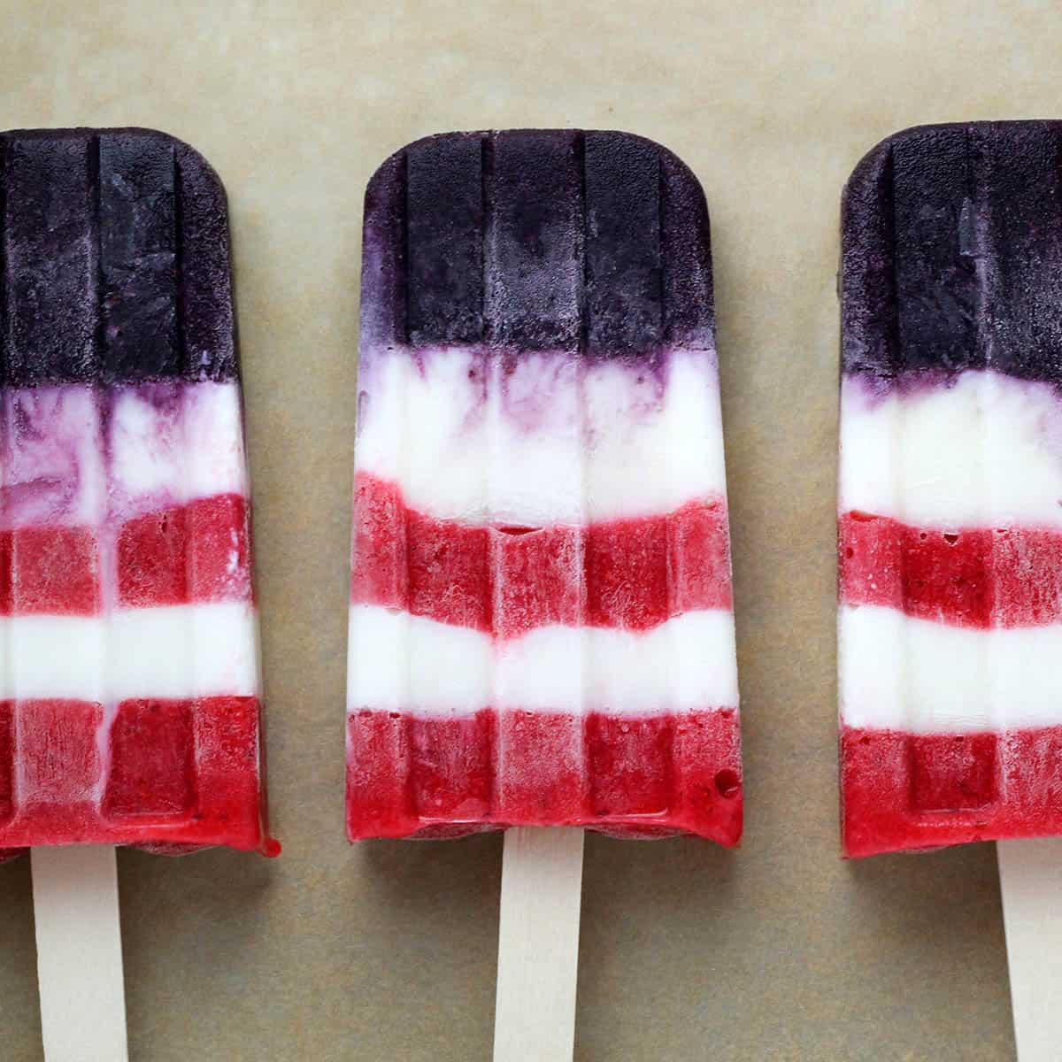 three layered popsicles with red, white, and blue layers