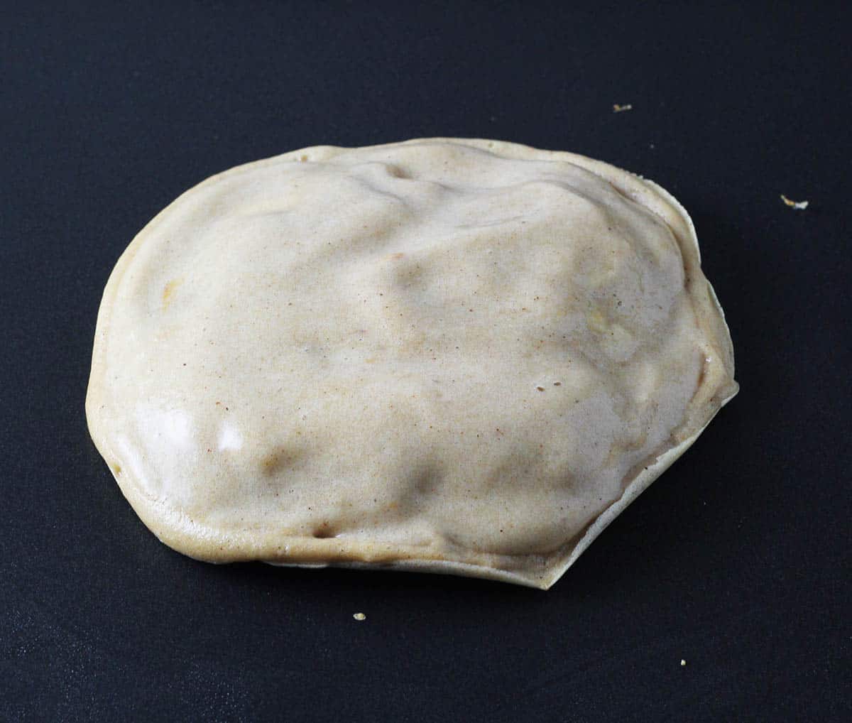 stuffed pancake process shot - pancake with stuffing and top layer of batter on a griddle