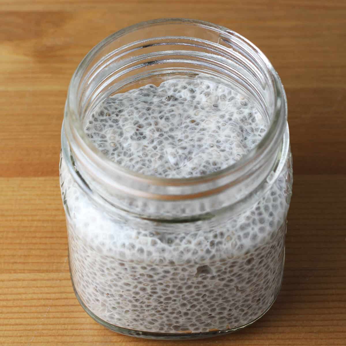 small mason jar of chia pudding on a wooden table