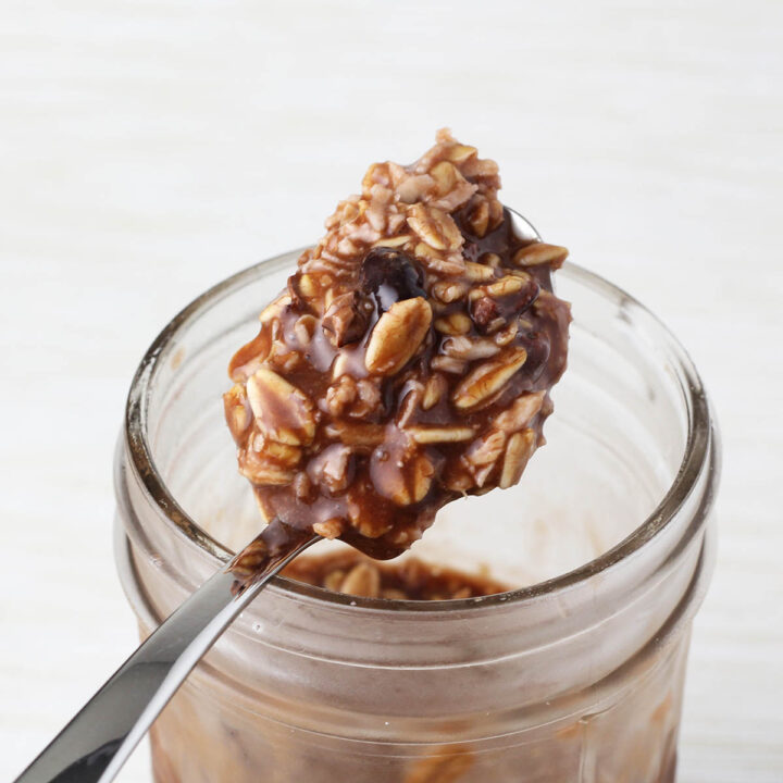 a spoonful of chocolate coconut overnight protein oats sitting on top of the jar used to make them