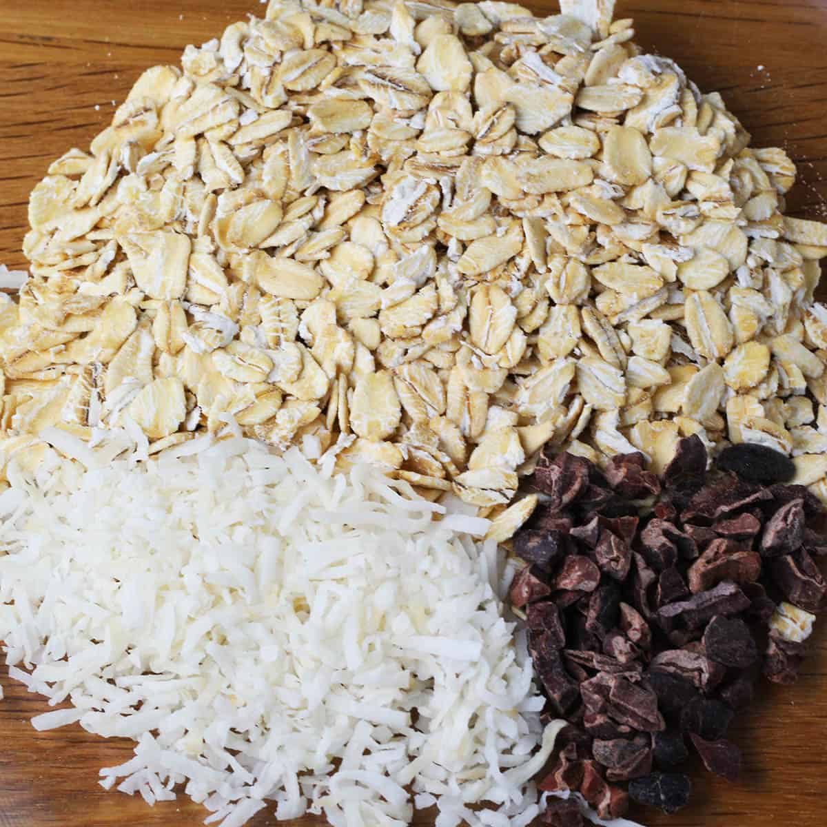 oats, shredded coconut, and cacao nibs on a wooden background and formed to shape a partitioned circle