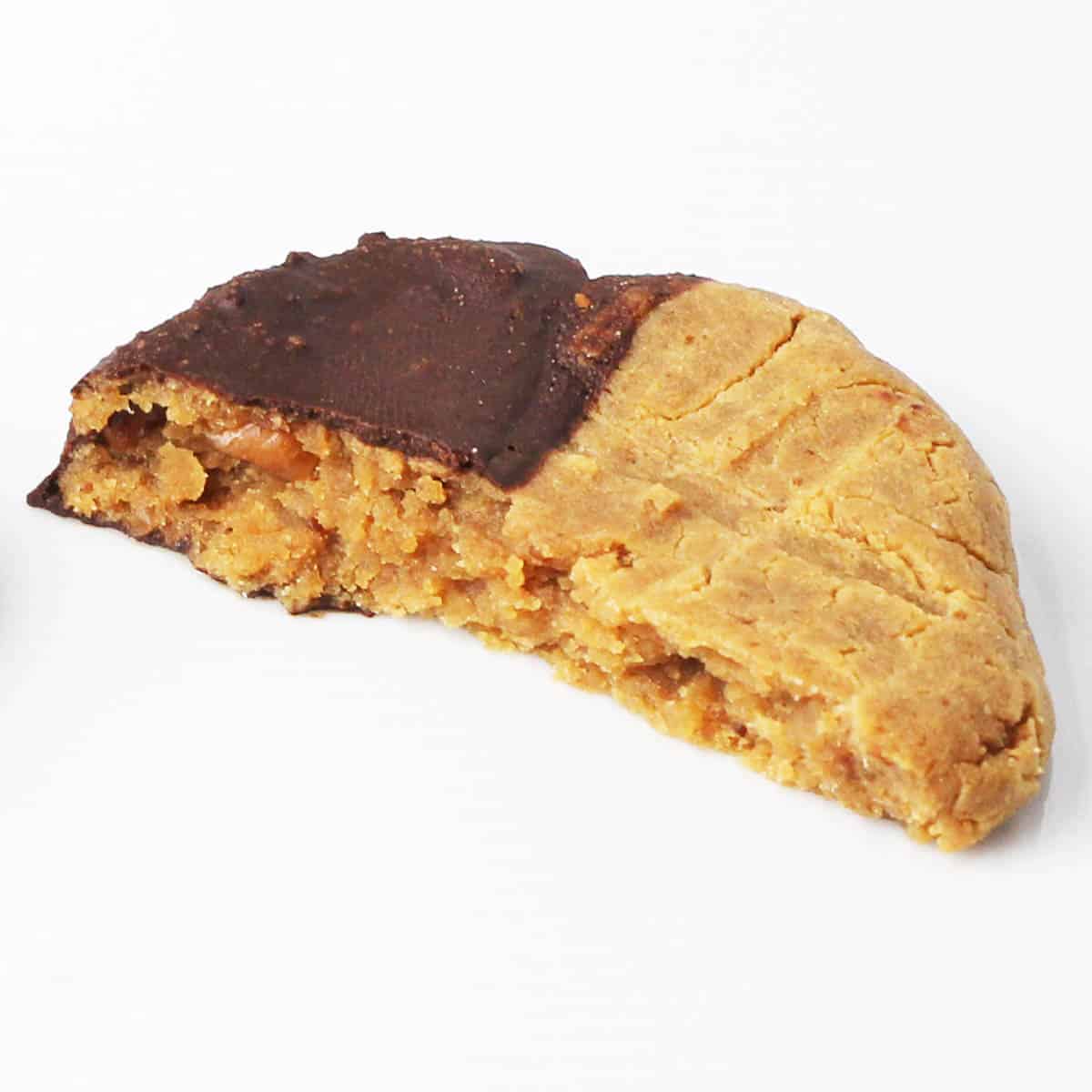 half of a chocolate dipped peanut butter protein cookie on a white background