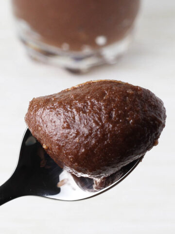 close up of a spoon of chocolate hazelnut frosting