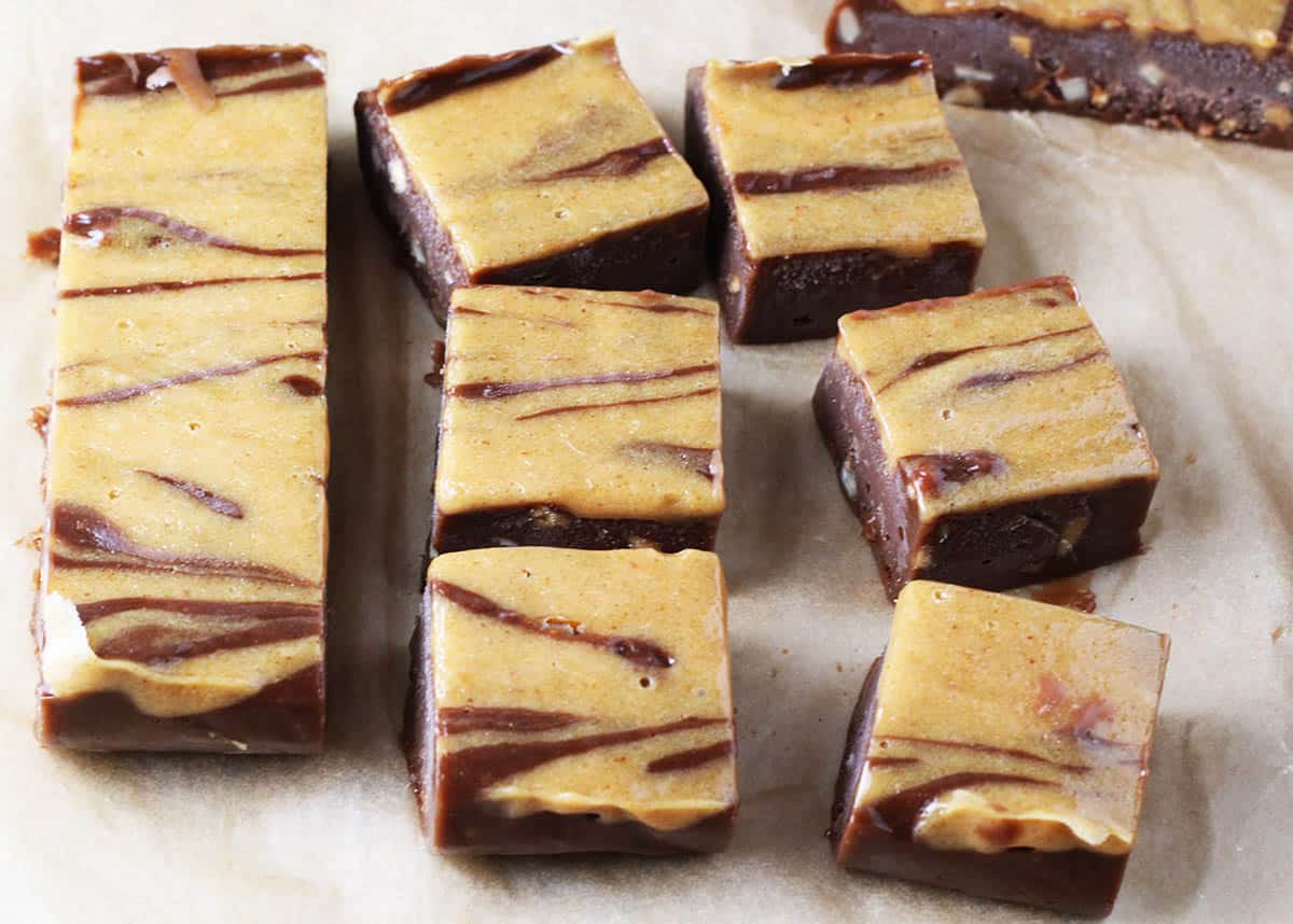 freshly cut chocolate peanut butter fudge on a sheet of unbleached parchment paper