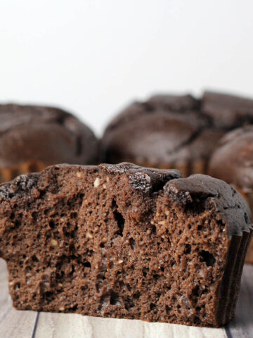 inside view of a chocolate protein muffin with a few more muffins in the background