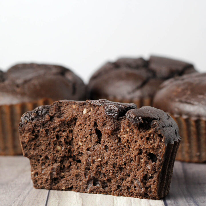 inside view of a chocolate protein muffin with a few more muffins in the background