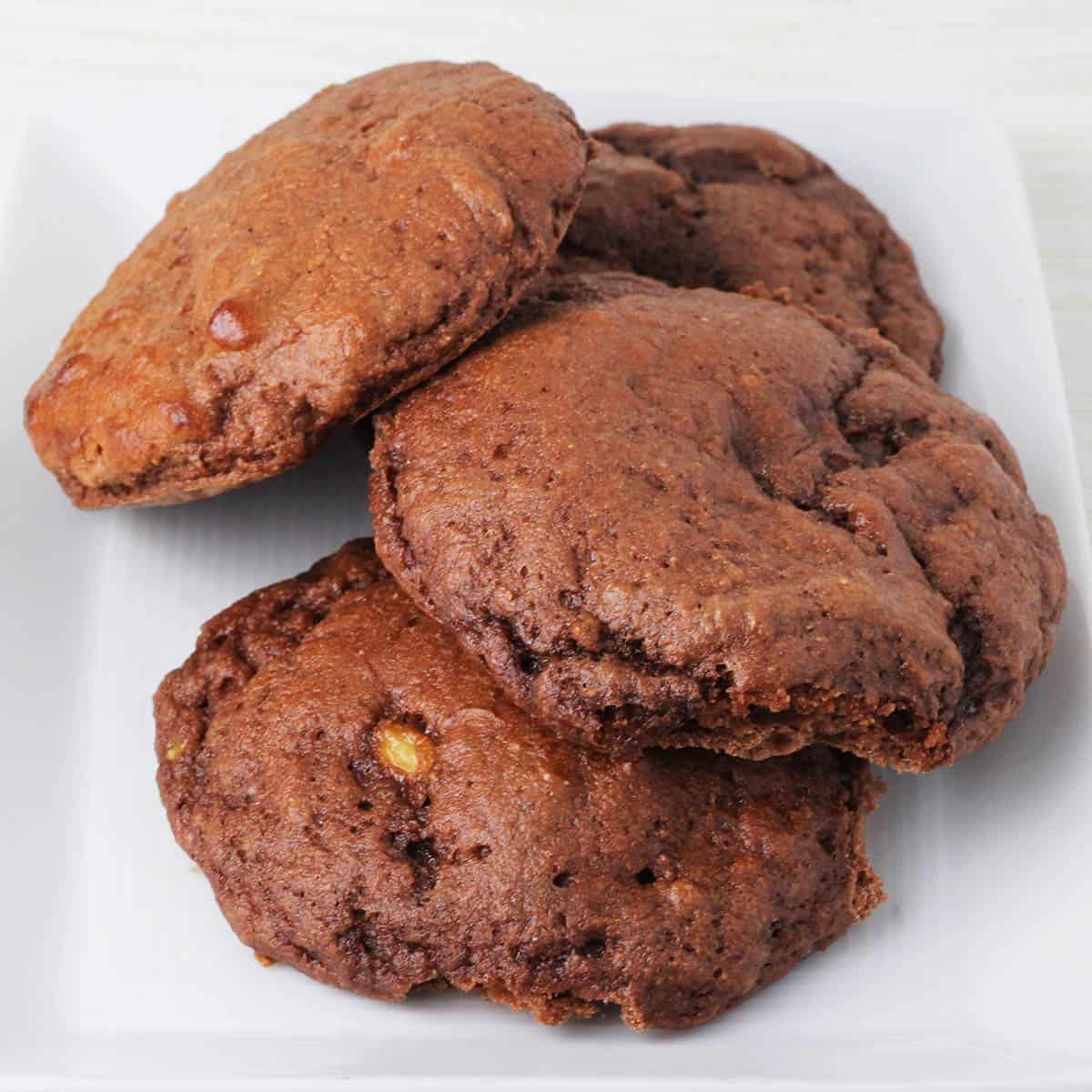 four chocolate cake-like chocolate cookies on a white plate