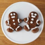 two iced gingerbread fudge pieces on a white cupcake stand on a wood table