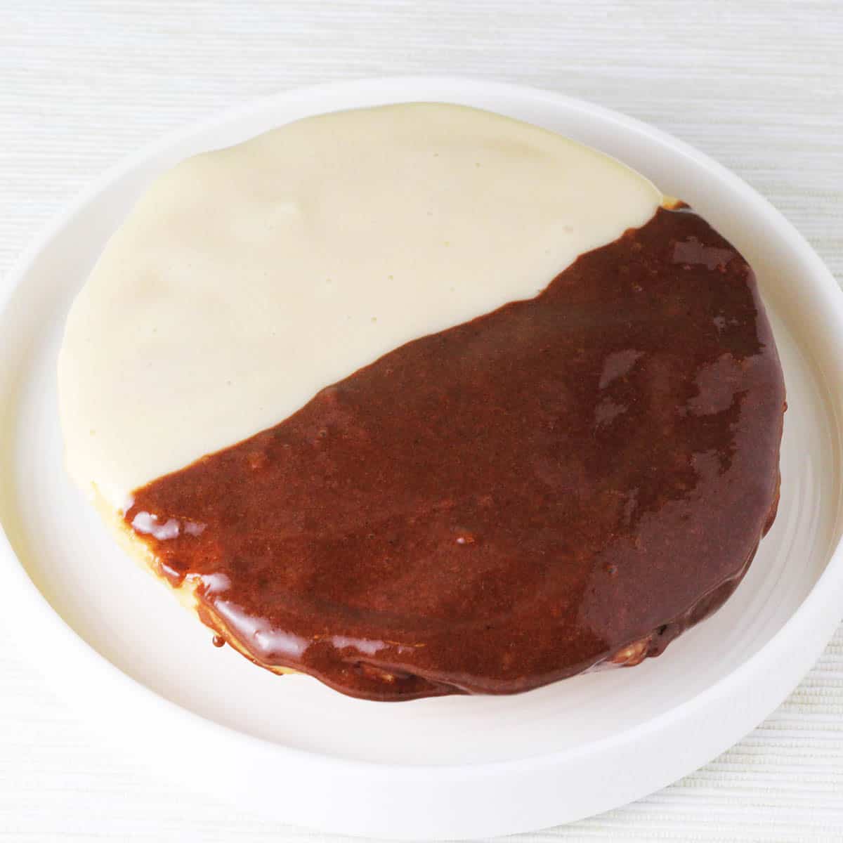 large black and white protein cookie on a round white plate
