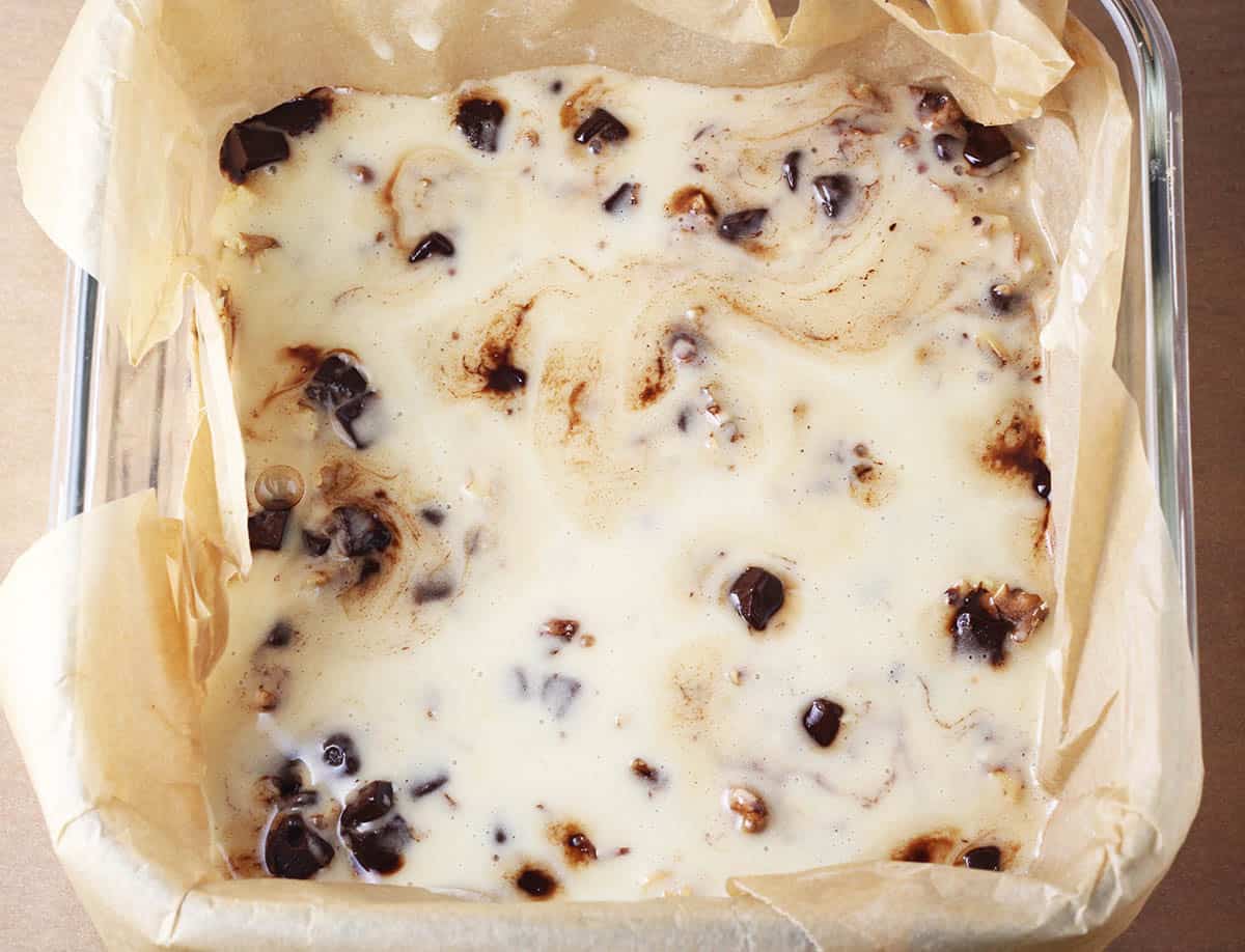 top (whey icing) layer of healthy magic bars in a square glass baking dish lined with unbleached parchment paper
