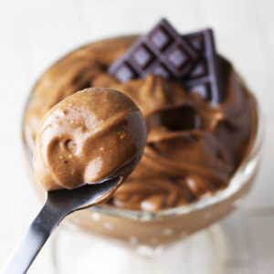 spoonful of keto chocolate avocado pudding with the rest of the serving dish in the background on a light background