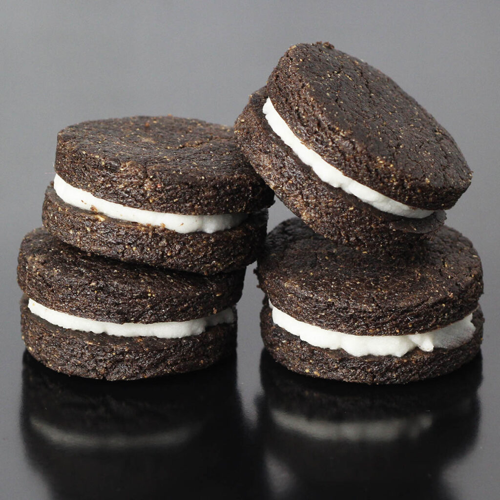 four oreo-inspired protein cookies on a black background