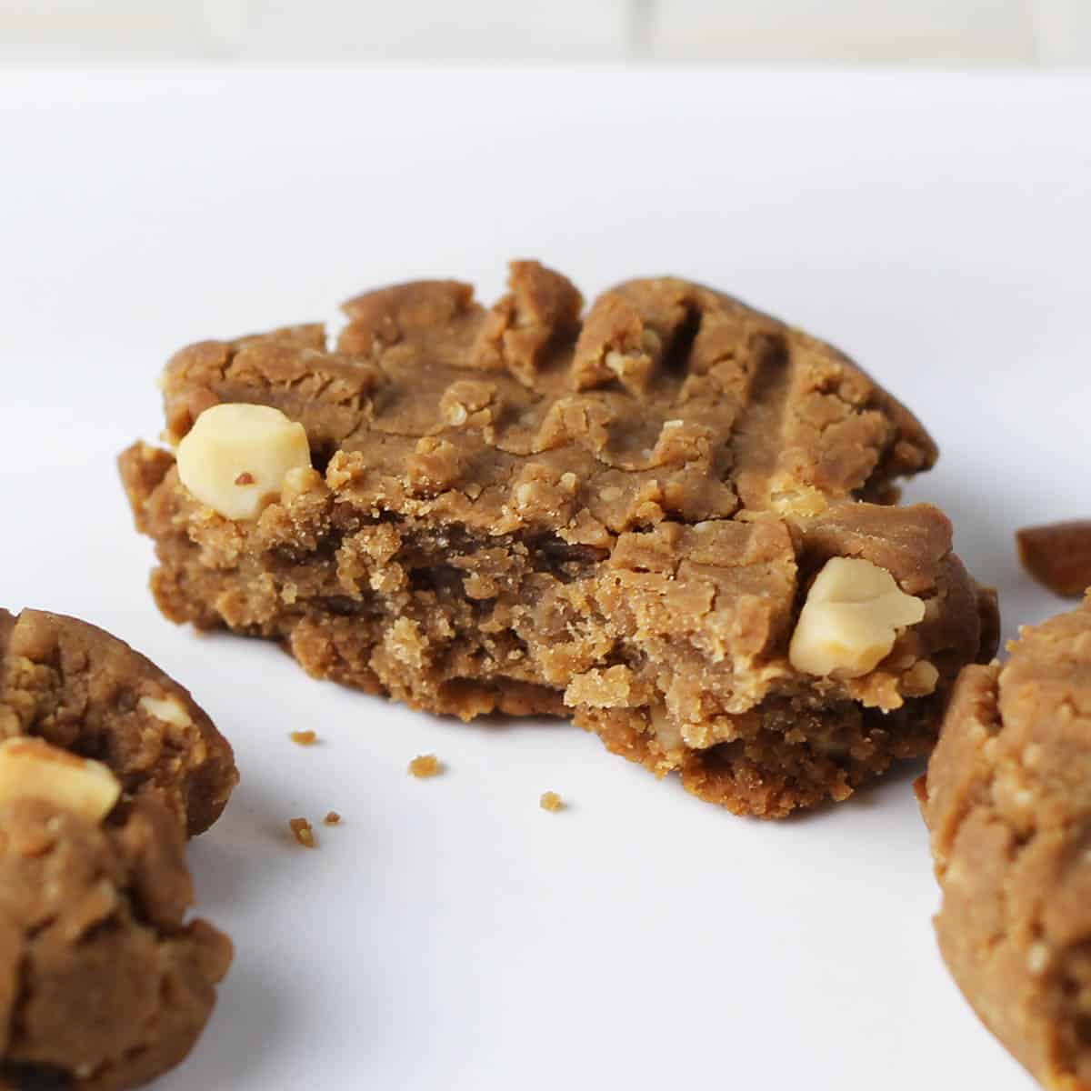 half a peanut butter cookie with fork marks on a white plate