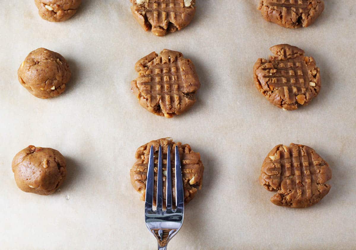 unbaked peanut butter cookies with a fork marking the cookies