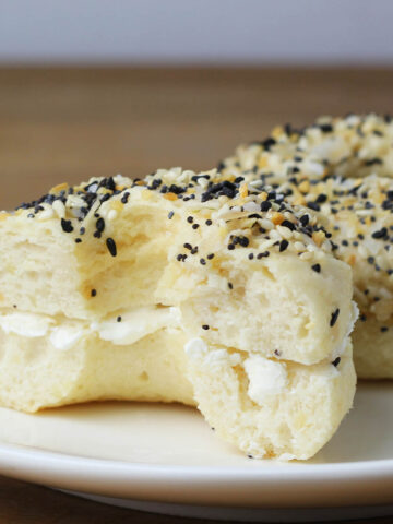 everything protein bagels sliced with cream cheese inside on a white plate