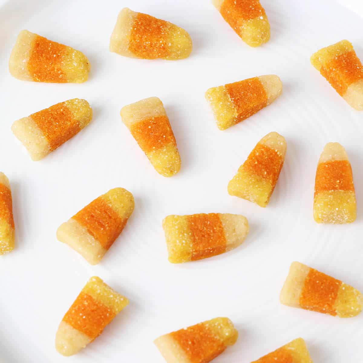 sixteen pieces of protein candy corn spread out on a white plate