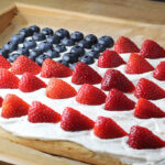 angled side view of flag cake on a wooden tray