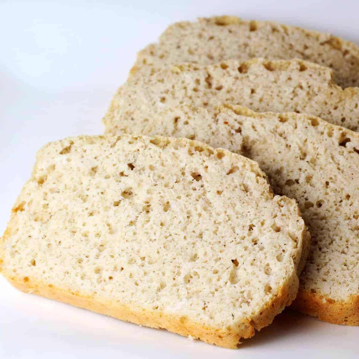 four slices of high protein gluten free bread layered on a white plate