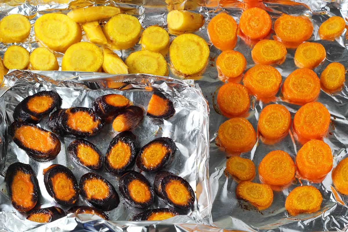 sliced rainbow carrots on a foil lined baking sheet