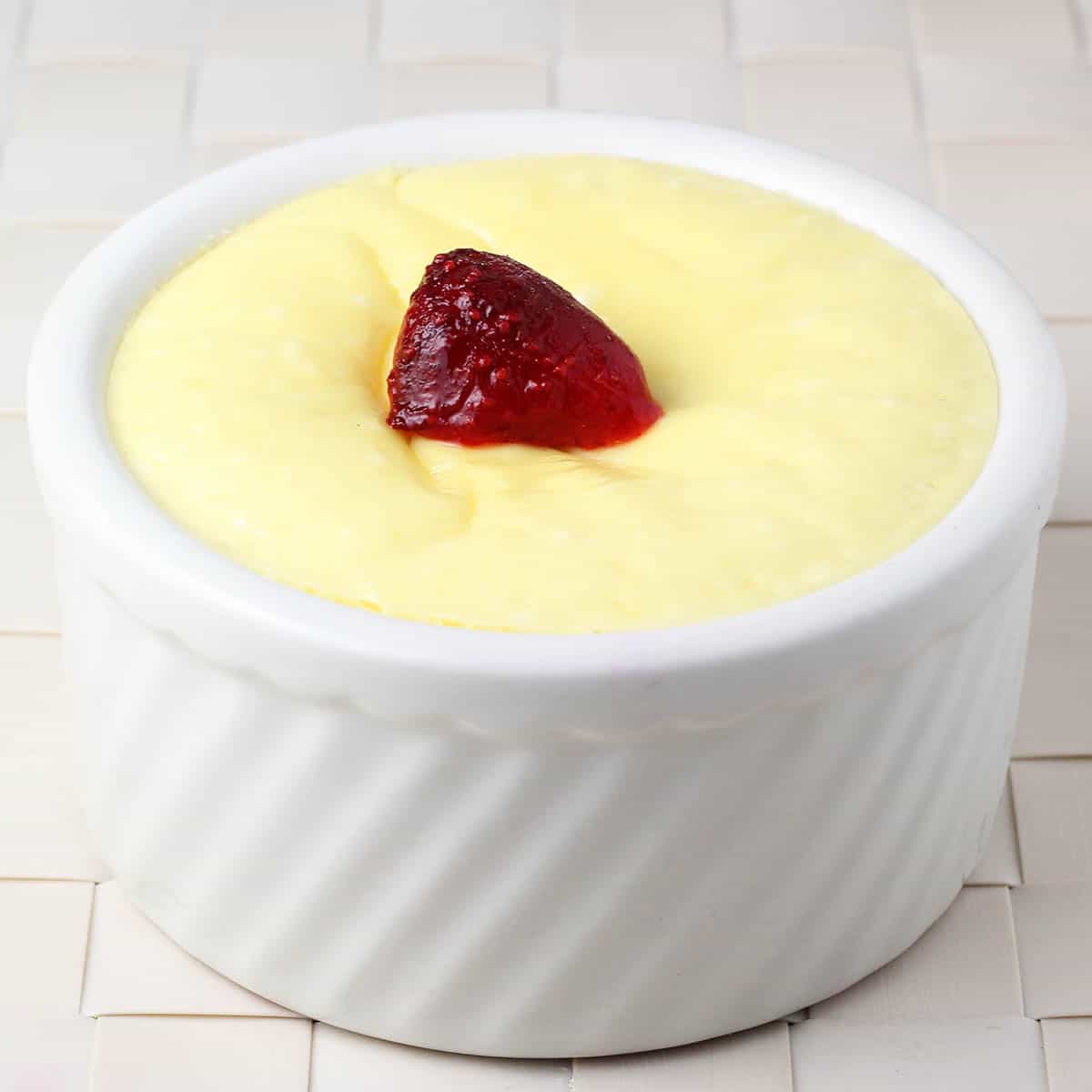 single serve of protein cheesecake in a ramekin with a strawberry on top