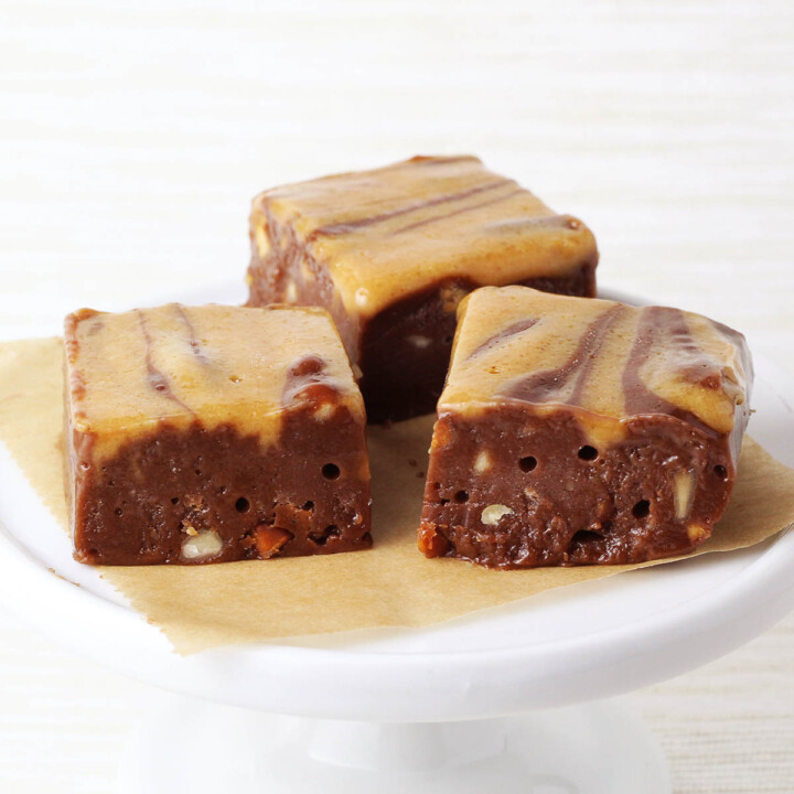 three pieces of chocolate protein fudge with peanut butter swirl on a white serving plate