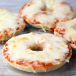 four pieces of pizza bagel on a glass plate