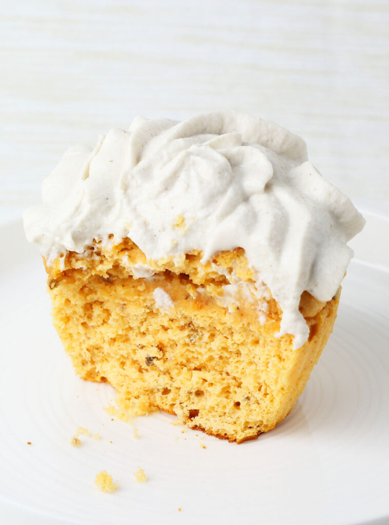inside view of one frosted healthy sweet potato cupcake on a white plate