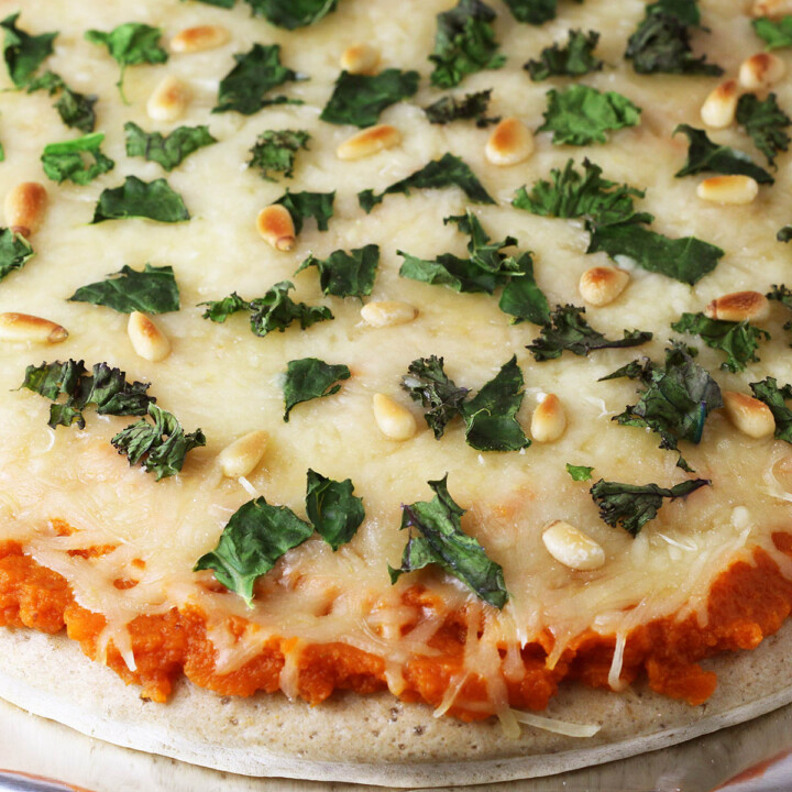 close up of whole pumpkin kale pizza on a sheet of foil