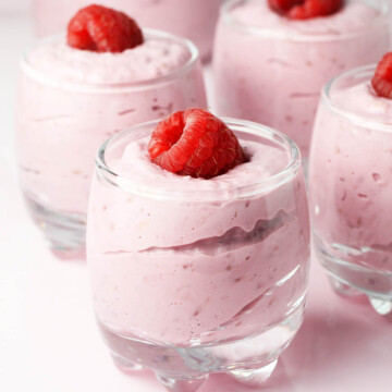 raspberry cheesecake mousse in shot glasses with a fresh raspberry on each
