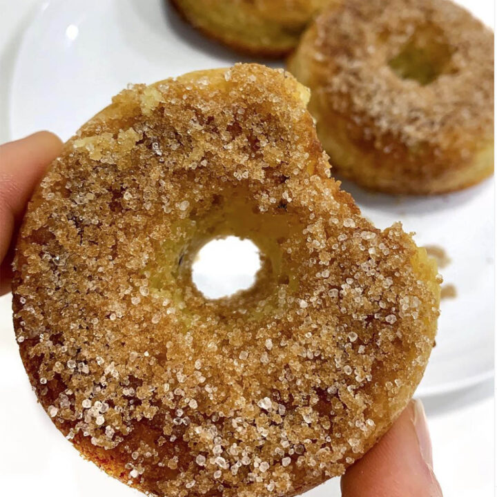 top view of a bitten donut topped with cinnamon sugar