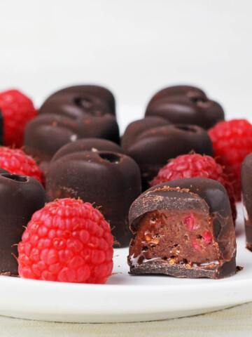 a plate full or raspberry filled chocolates with one cut open
