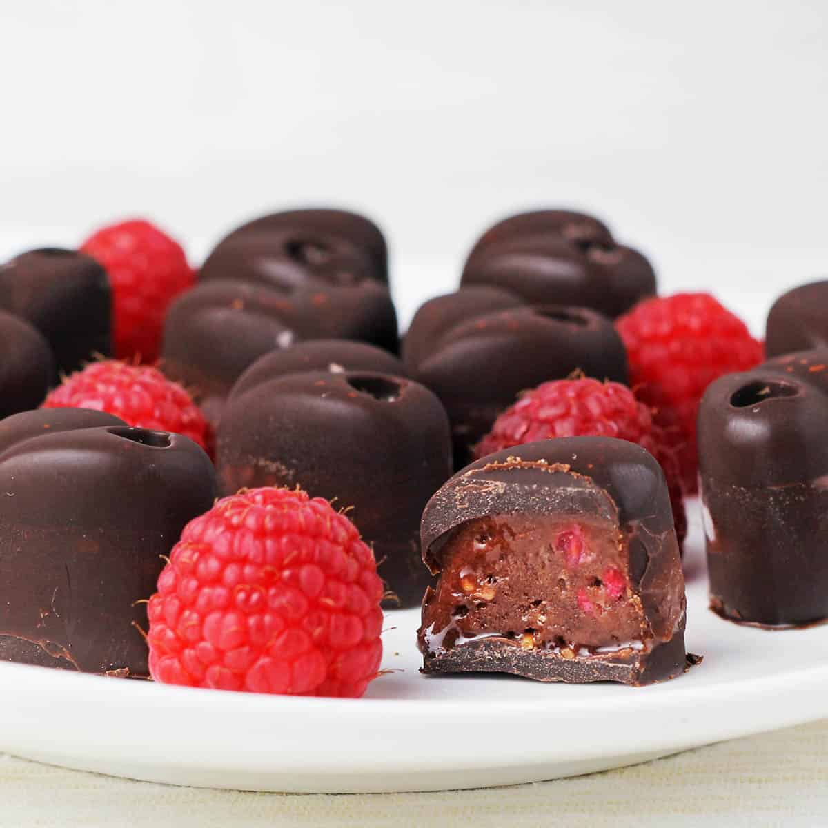 a plate full or raspberry filled chocolates with one cut open