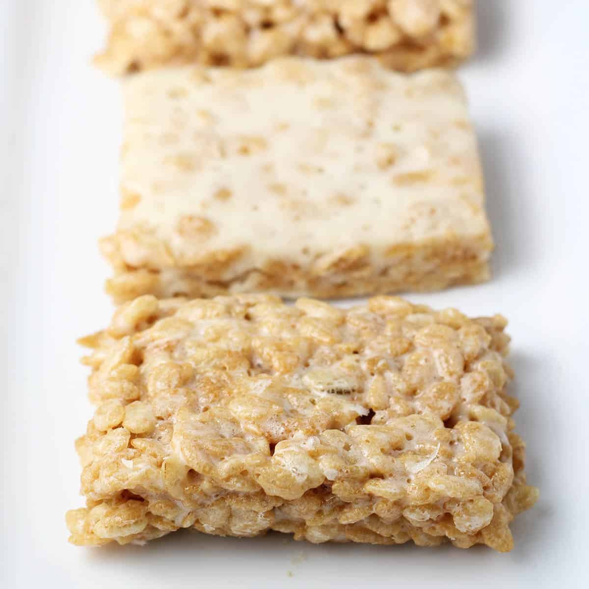 three crispy rice protein treats on a white plate