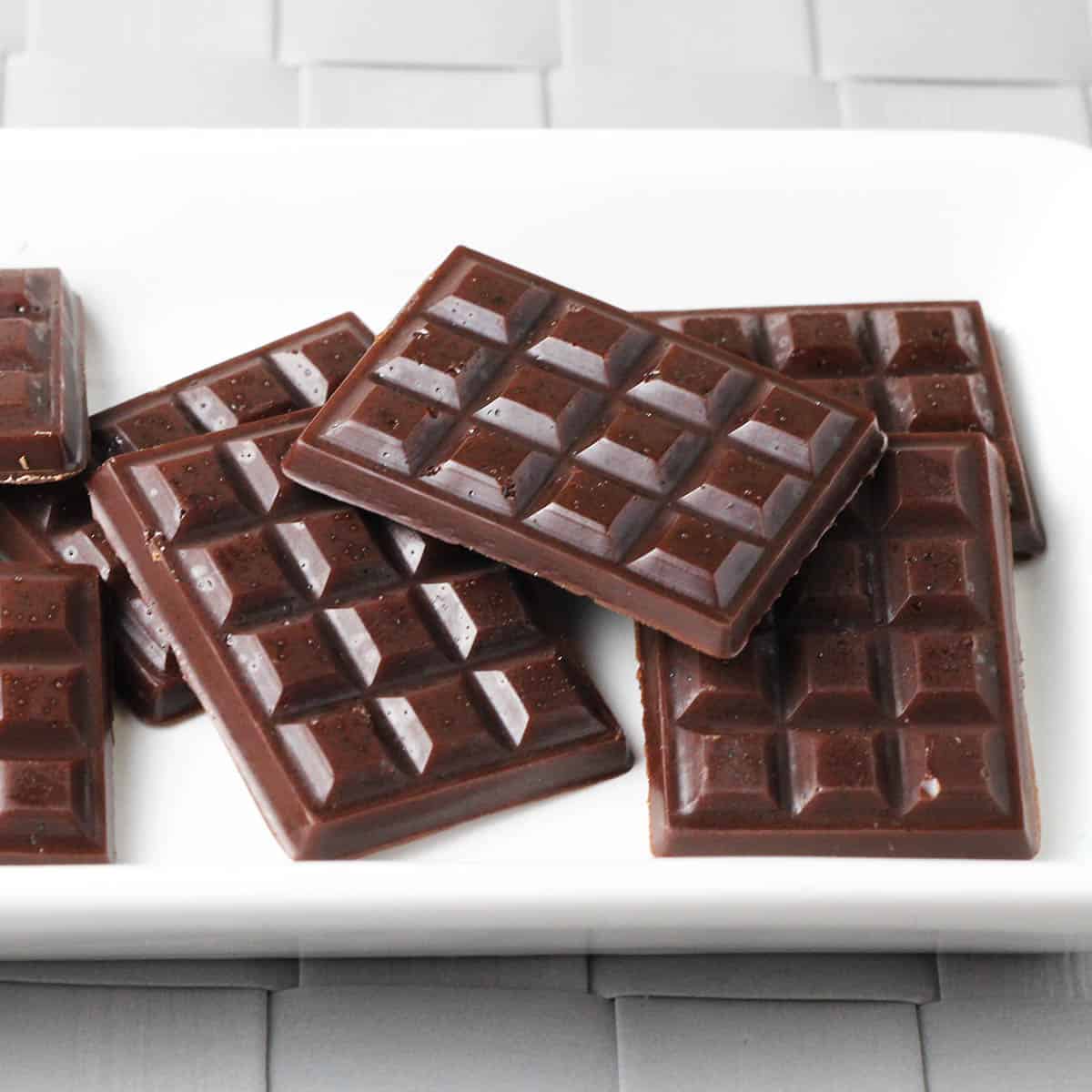 several pieces of raw chocolate on a white plate