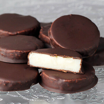 a pile of sugar free peppermint patties with one cut to show the inside