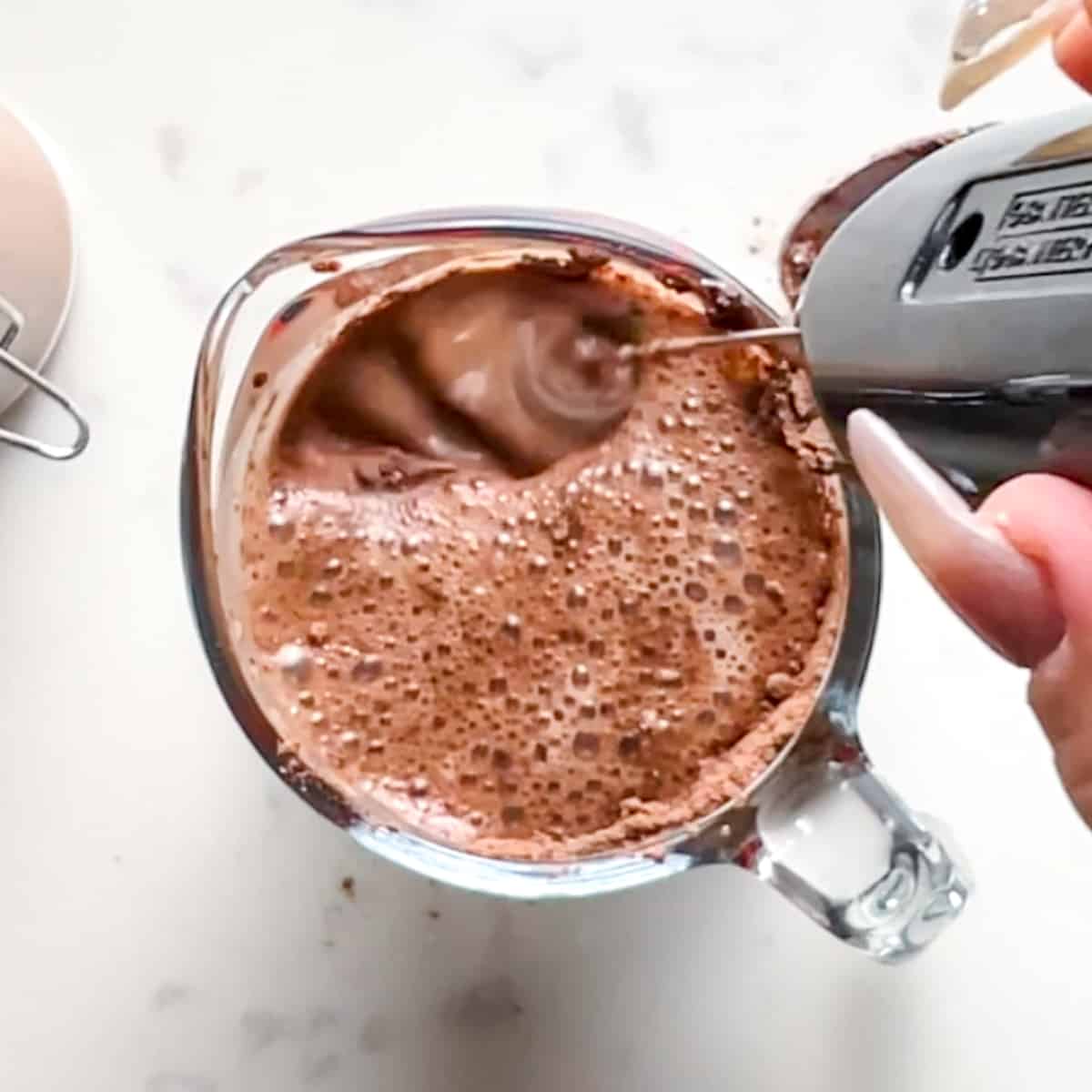 protein hot chocolate being mixed with a milk frother