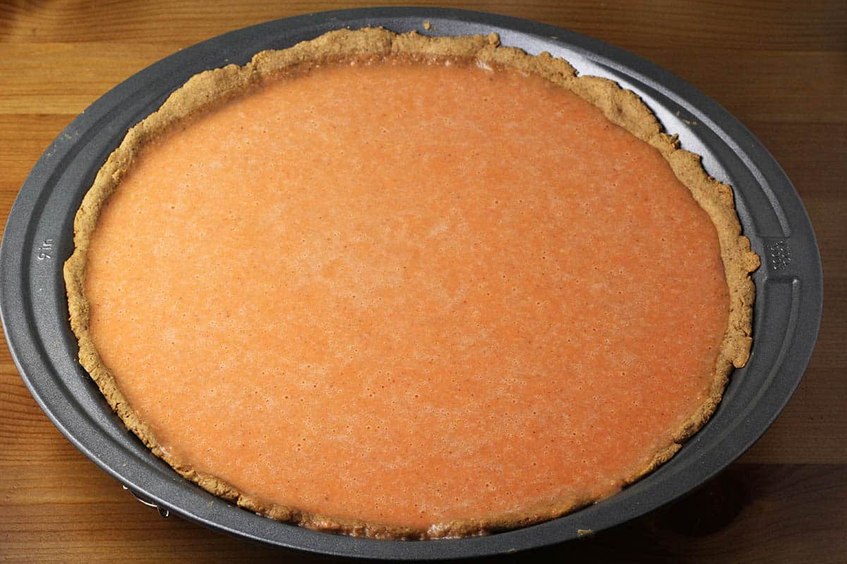 unbaked sweet potato pie in a metal pie pan