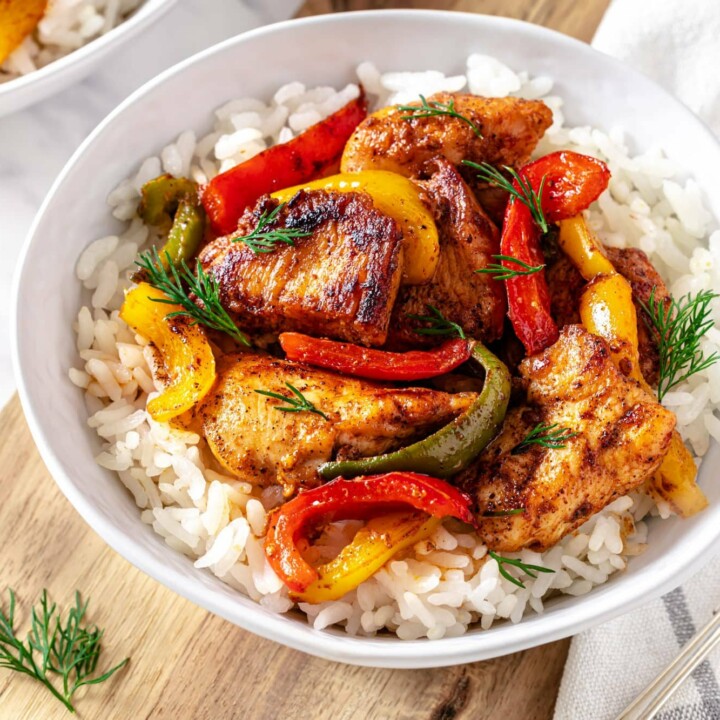 bowl of chicken and bell peppers over white rice.
