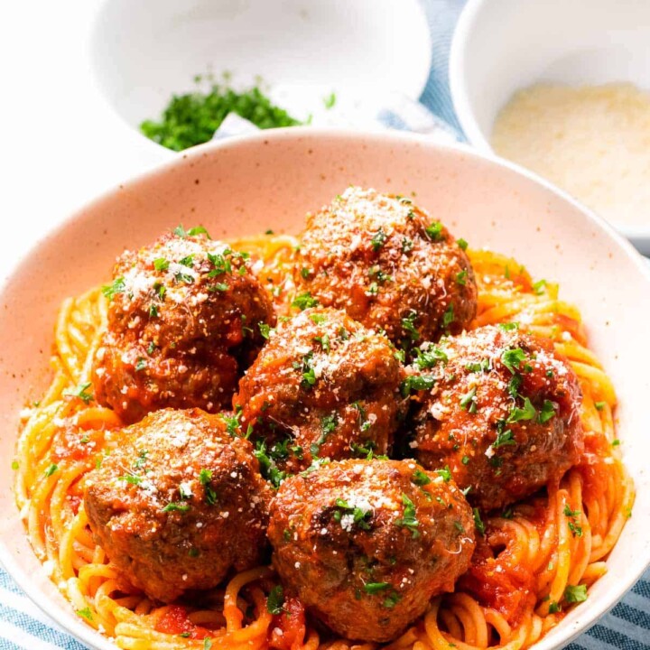bowl of Italian meatballs on a bed of spaghetti.