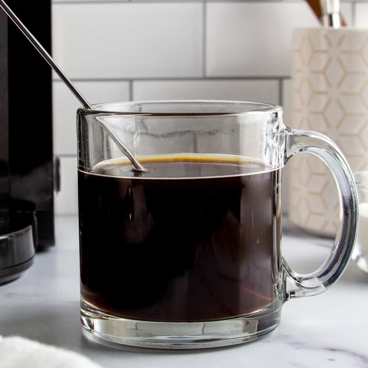cup of black protein coffee in a glass mug.