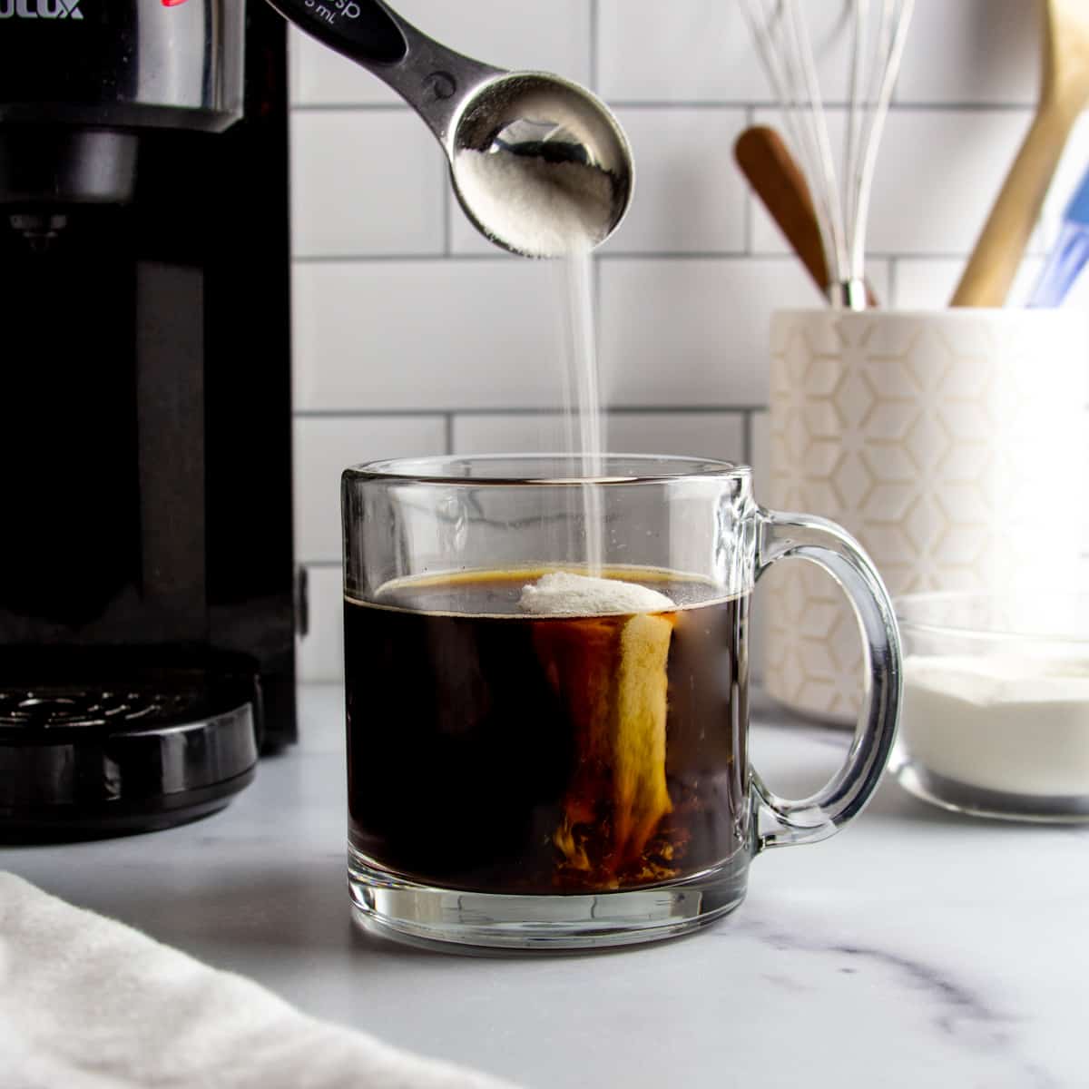 collagen protein being added to a cup of hot coffee