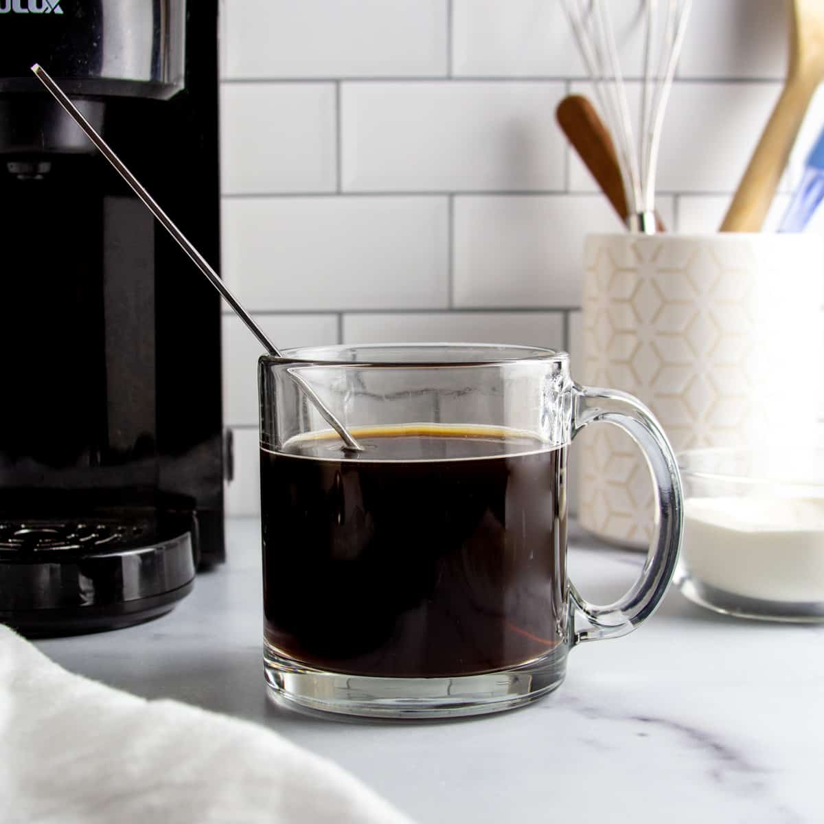 a glass mug with black coffee after adding collagen protein
