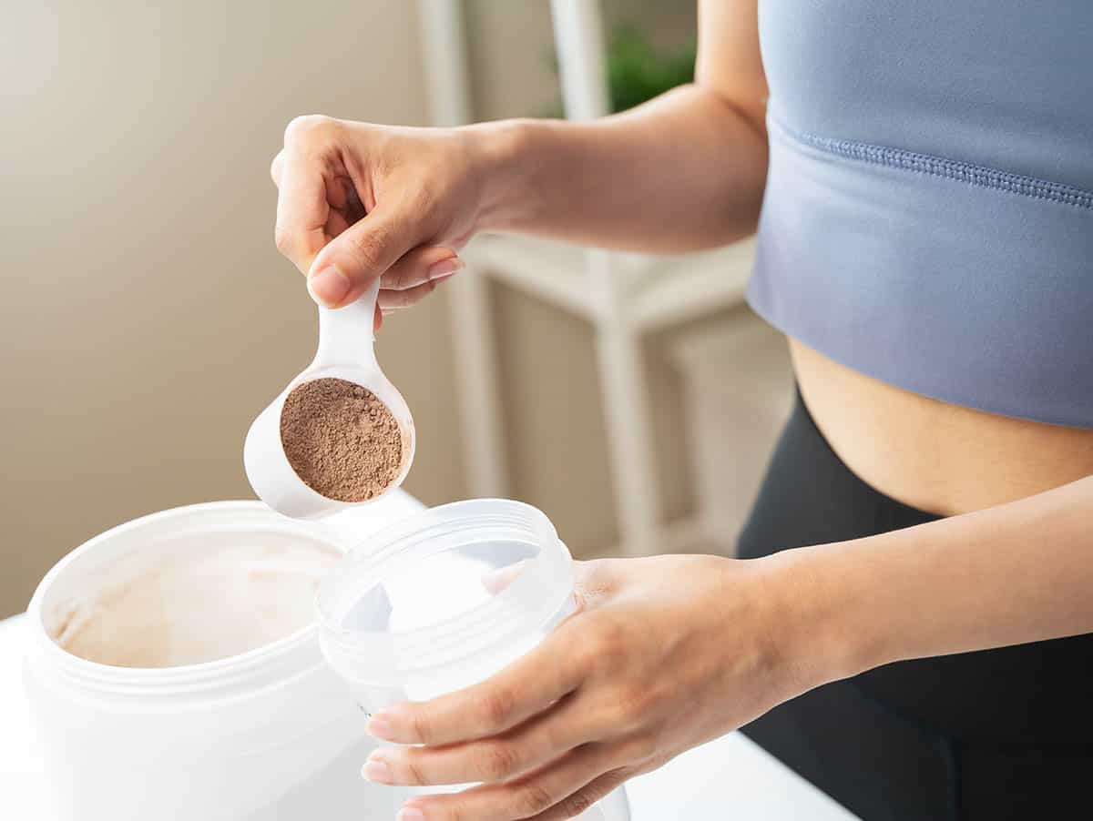 fit woman making a chocolate protein shake.
