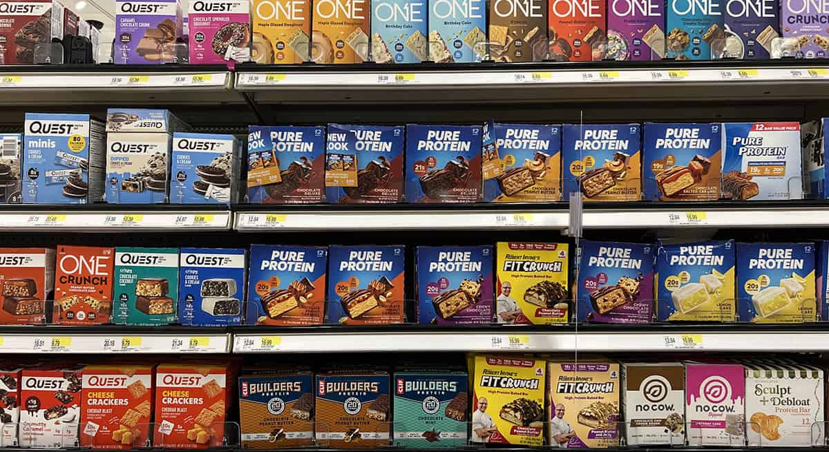 4 store shelves full of protein bars.