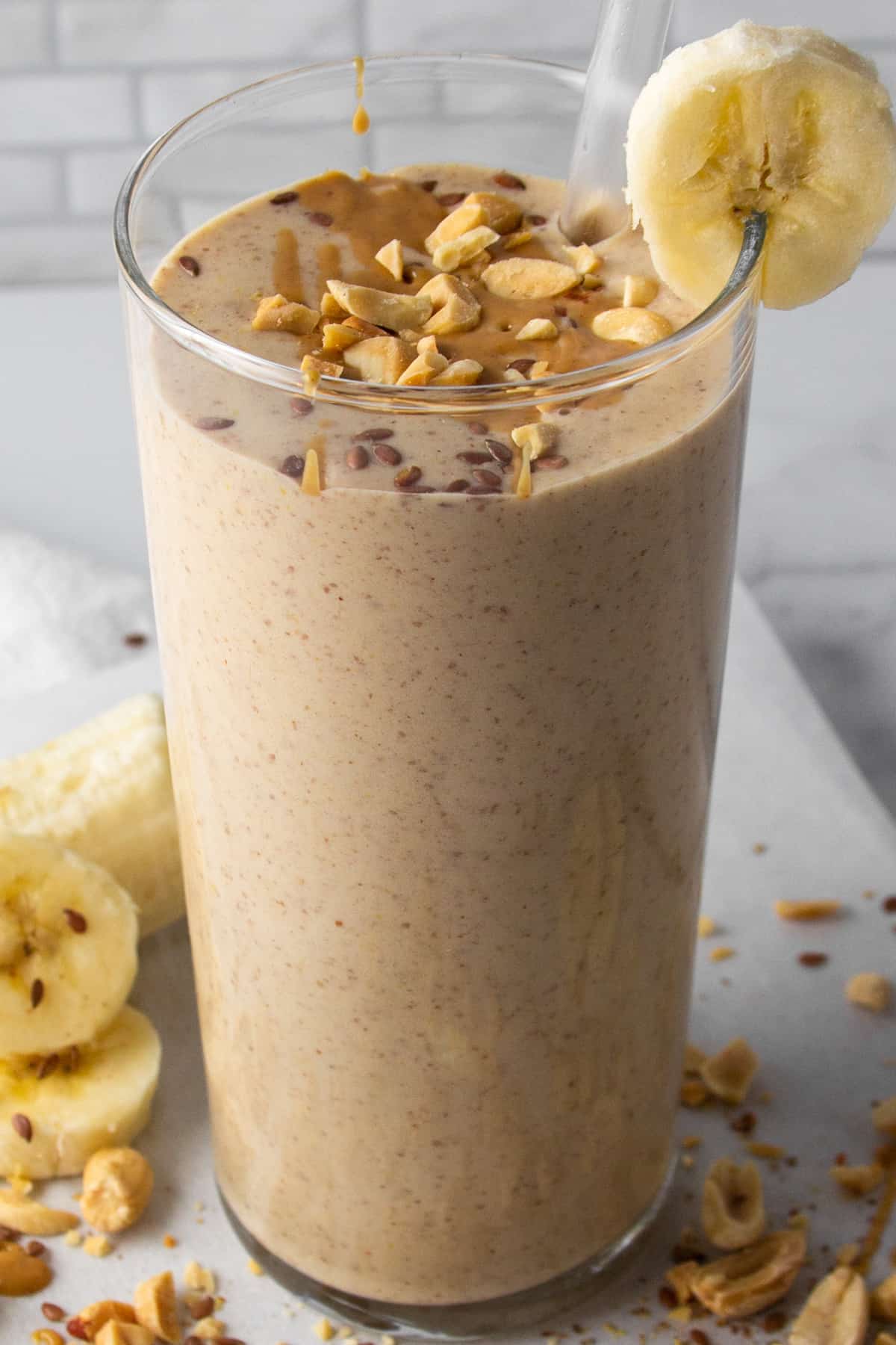 banana peanut butter protein shake with flax seeds in a glass.