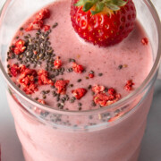 strawberry chia protein smoothie with chia and dried strawberry on top.