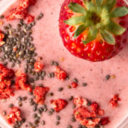 strawberry chia protein smoothie with chia and dried strawberry on top.